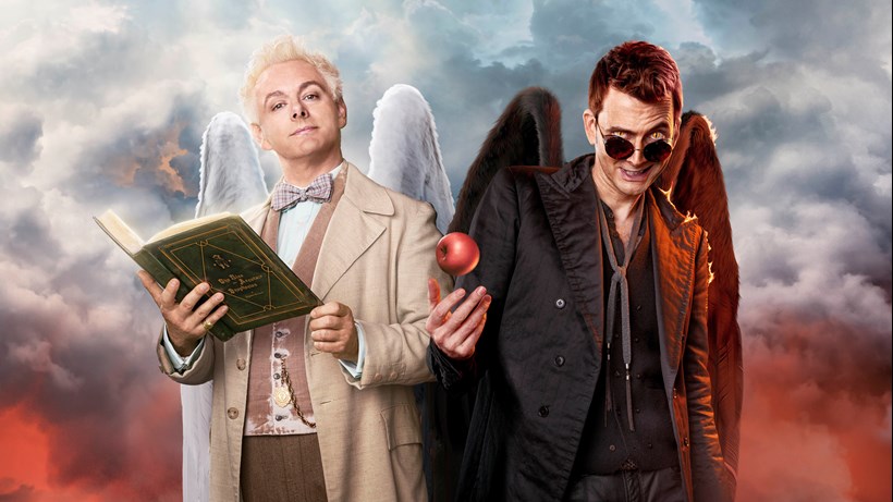 Image shows actors Michael Sheen and David Tennant as the angel Aziraphale and demon Crowley. The actors are stood against a cloudy backdrop.